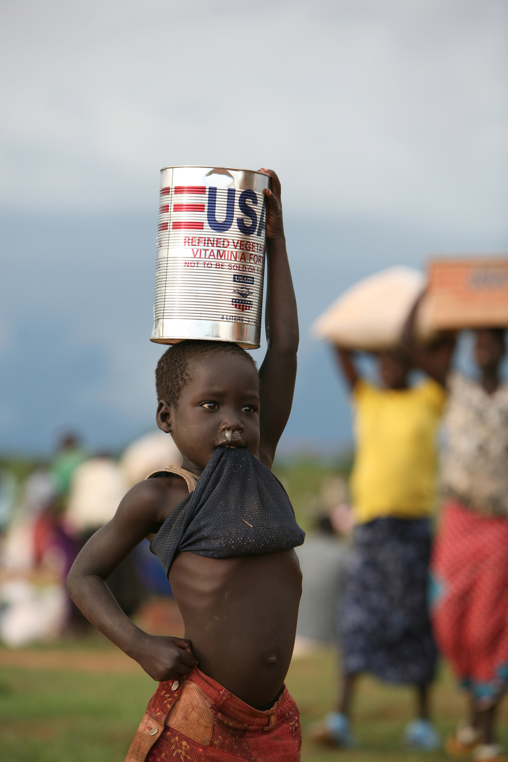 A child carrying a tin of cooking oil