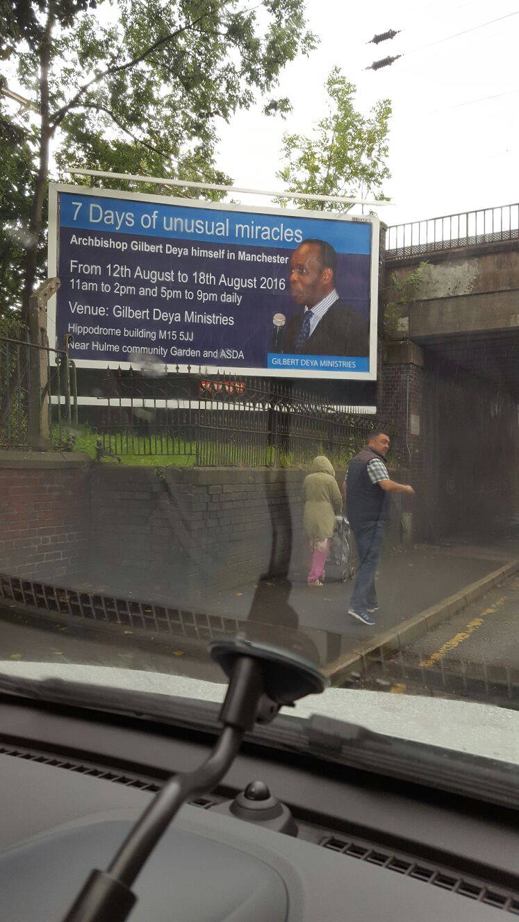 A billboard detailing Gilbert Deya "unusual miracles" in Manchester