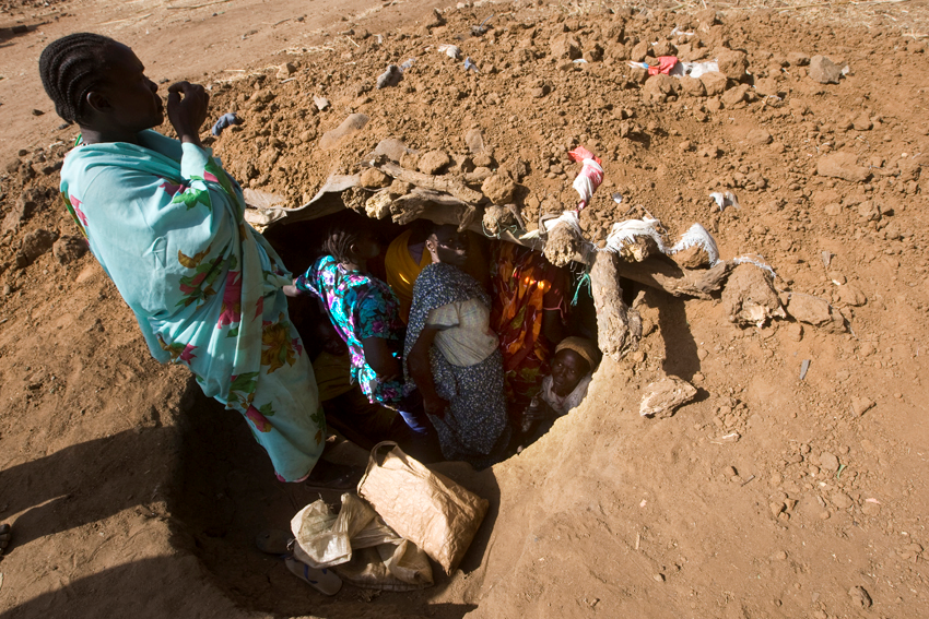 A group of women inside a foxhole after a bombing raid