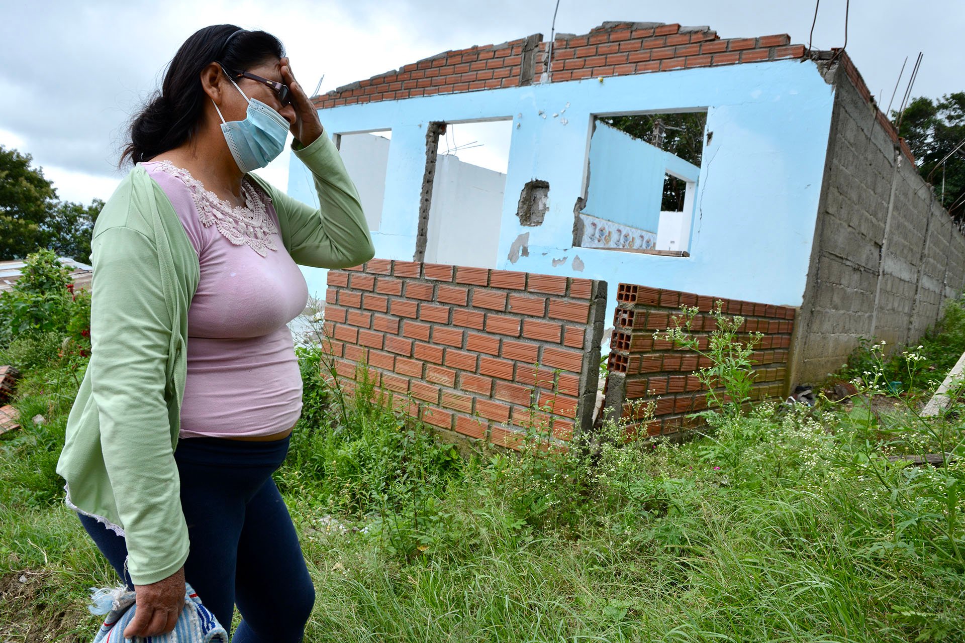 The string of disasters left thousands of survivors homeless. María Nancy, pictured here in front of her ruined home, said the tents provided by the authorities were unsuitable for vulnerable people, like her elderly mother, due to the searing tropical he