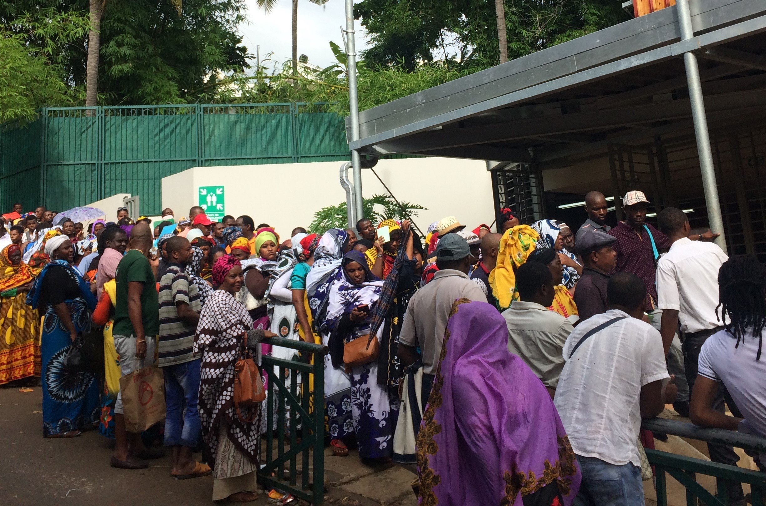 Comorians wait in line outside the office for foreign affairs in Mayotte