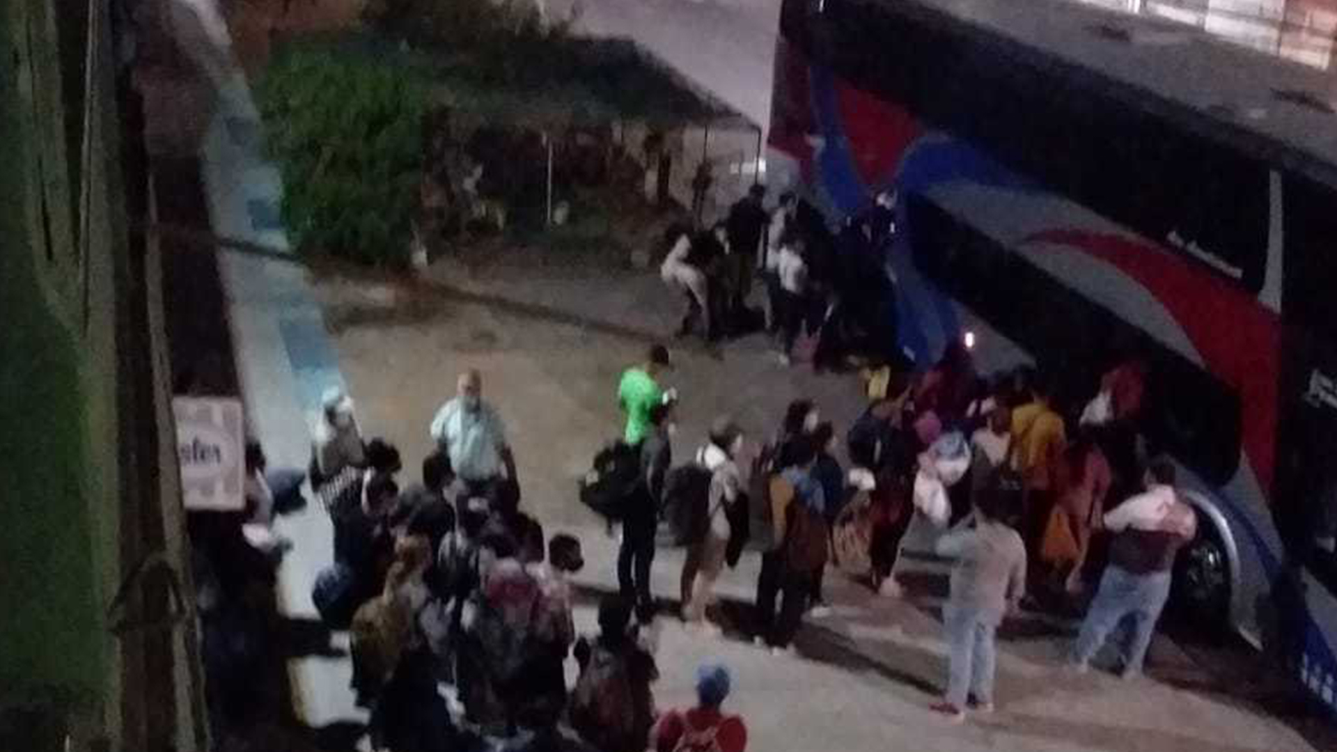 A group of people waiting for a bus at the border in Iquique to take them to Santiago. 