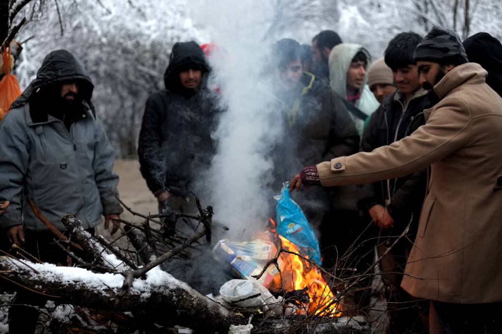 Migrants try to warm up around the fire in Vučjak in early December. There was no electricity or heating, so they resorted to burning all the plastic and wood they could find.