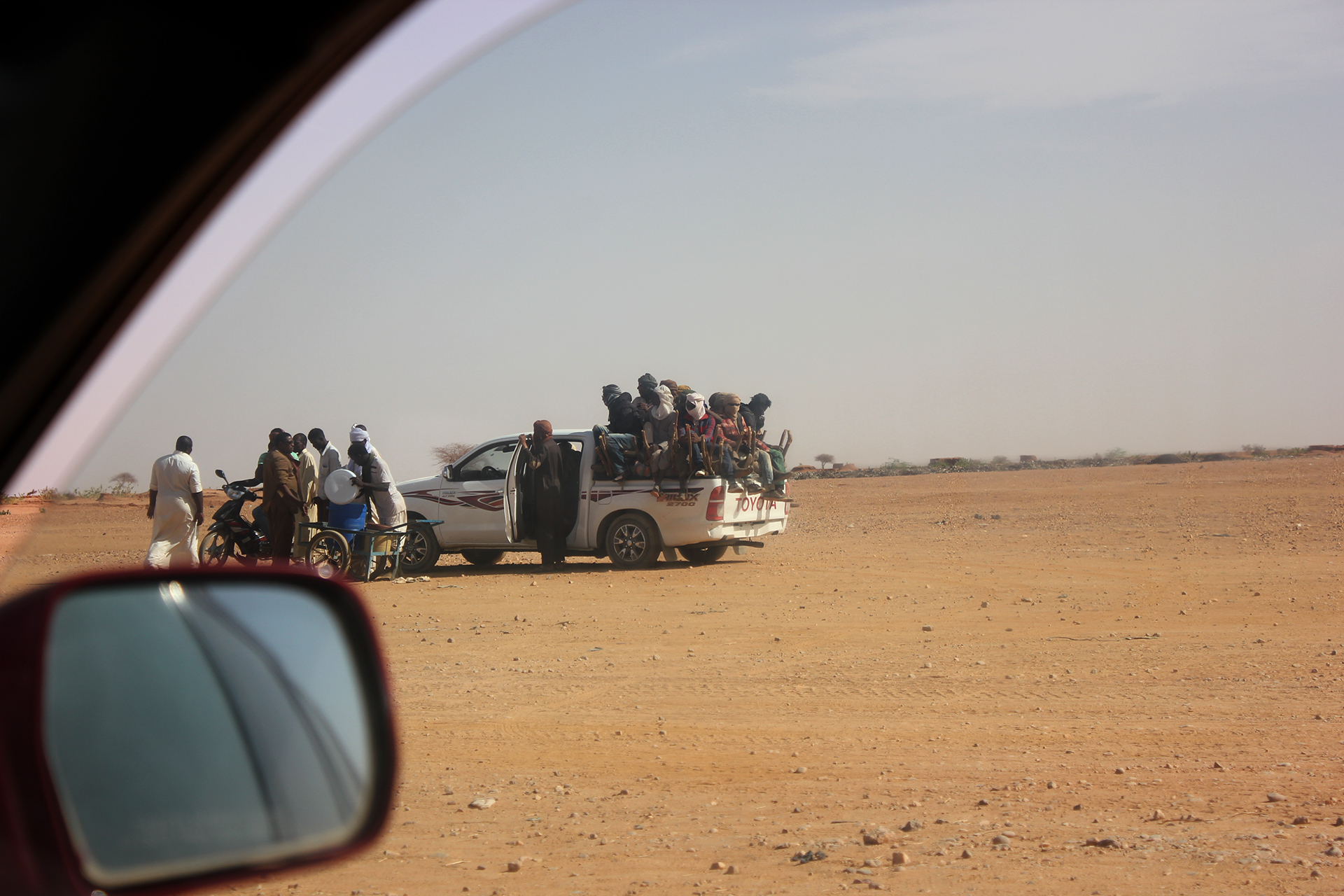 Migrants load into the back of a pickup at a checkpoint outside of Agadez, Niger before beginning the long journey across the Sahara to Libya, March 2018.