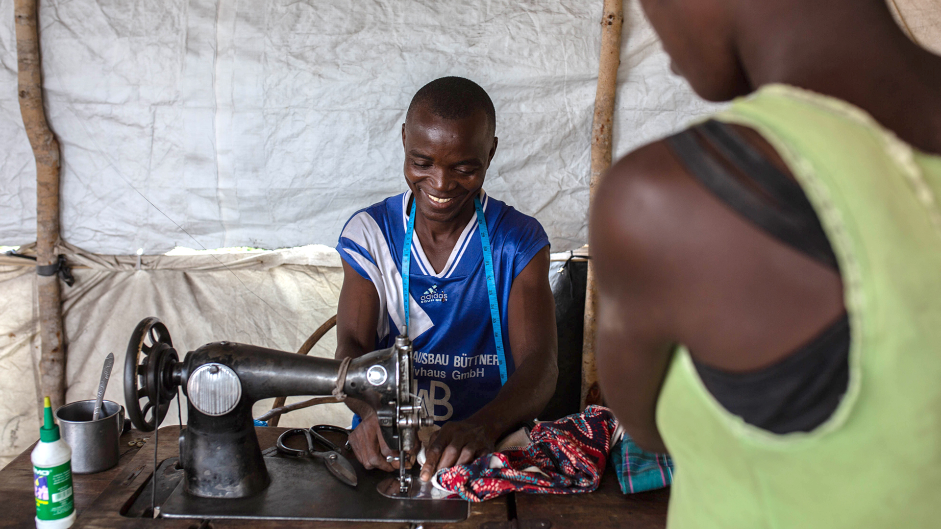 A tailor has opened up a small business inside a tent at Mutua resettlement site.