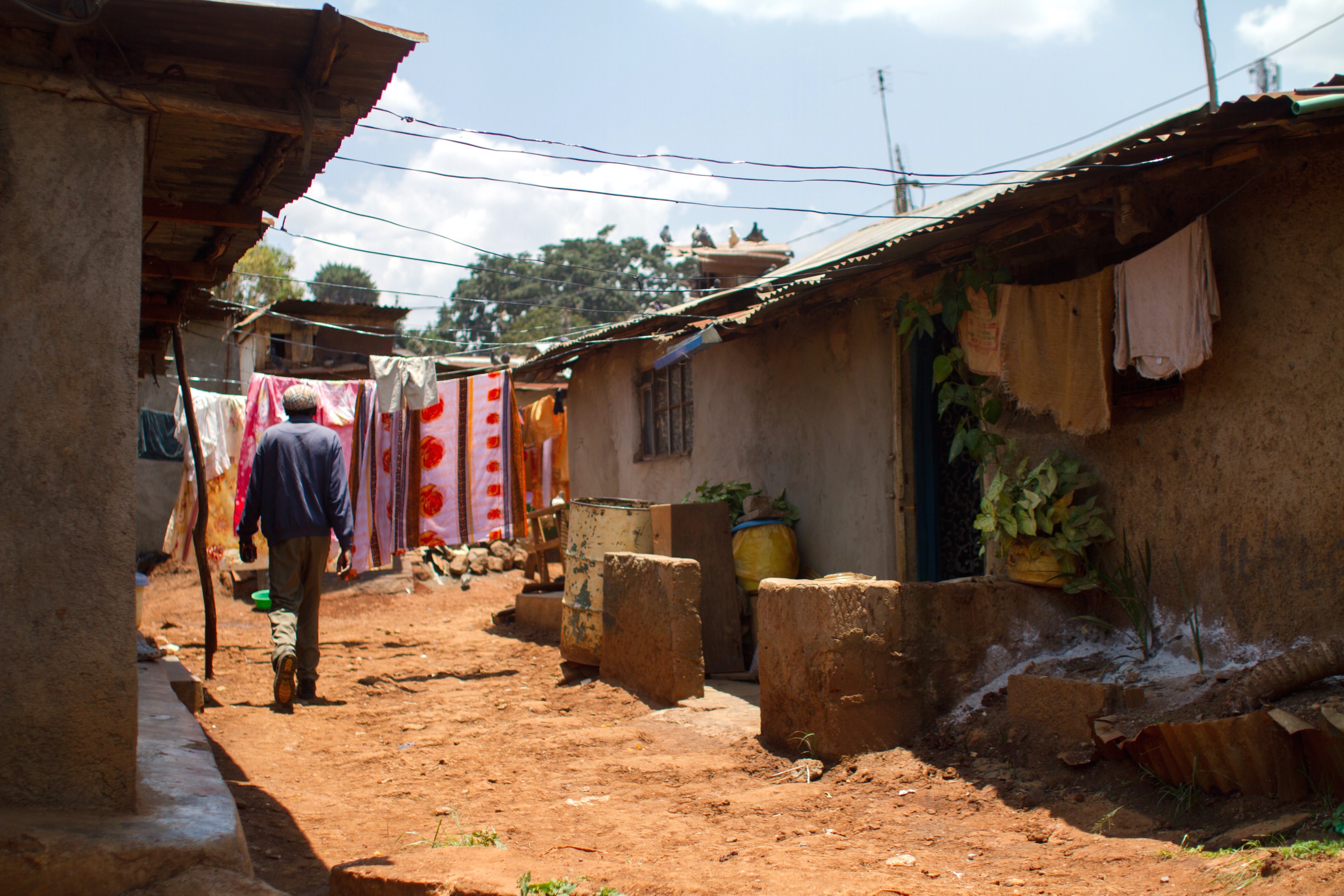 A man walks between homes in Kibera