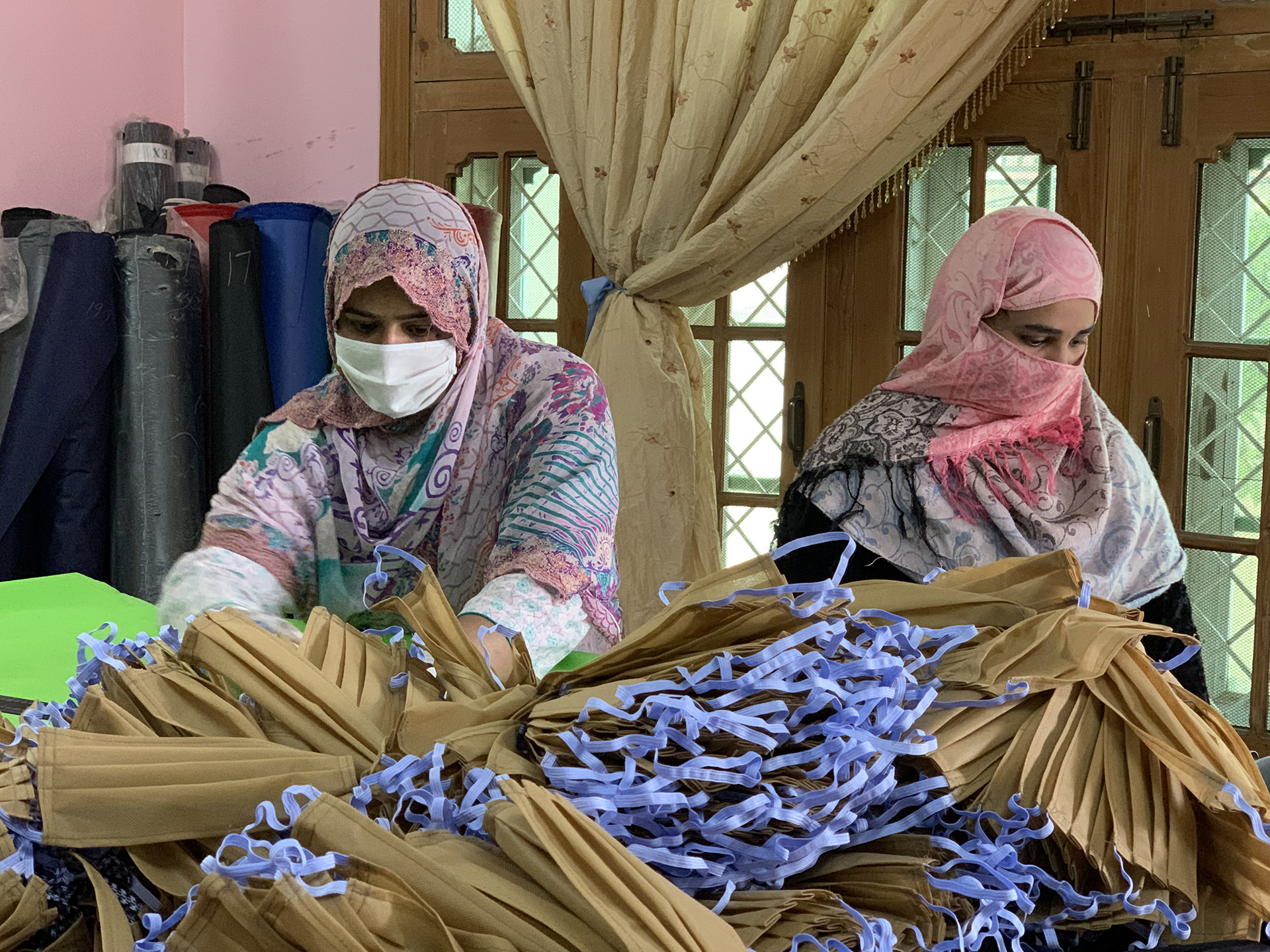 Two workers prepare face masks