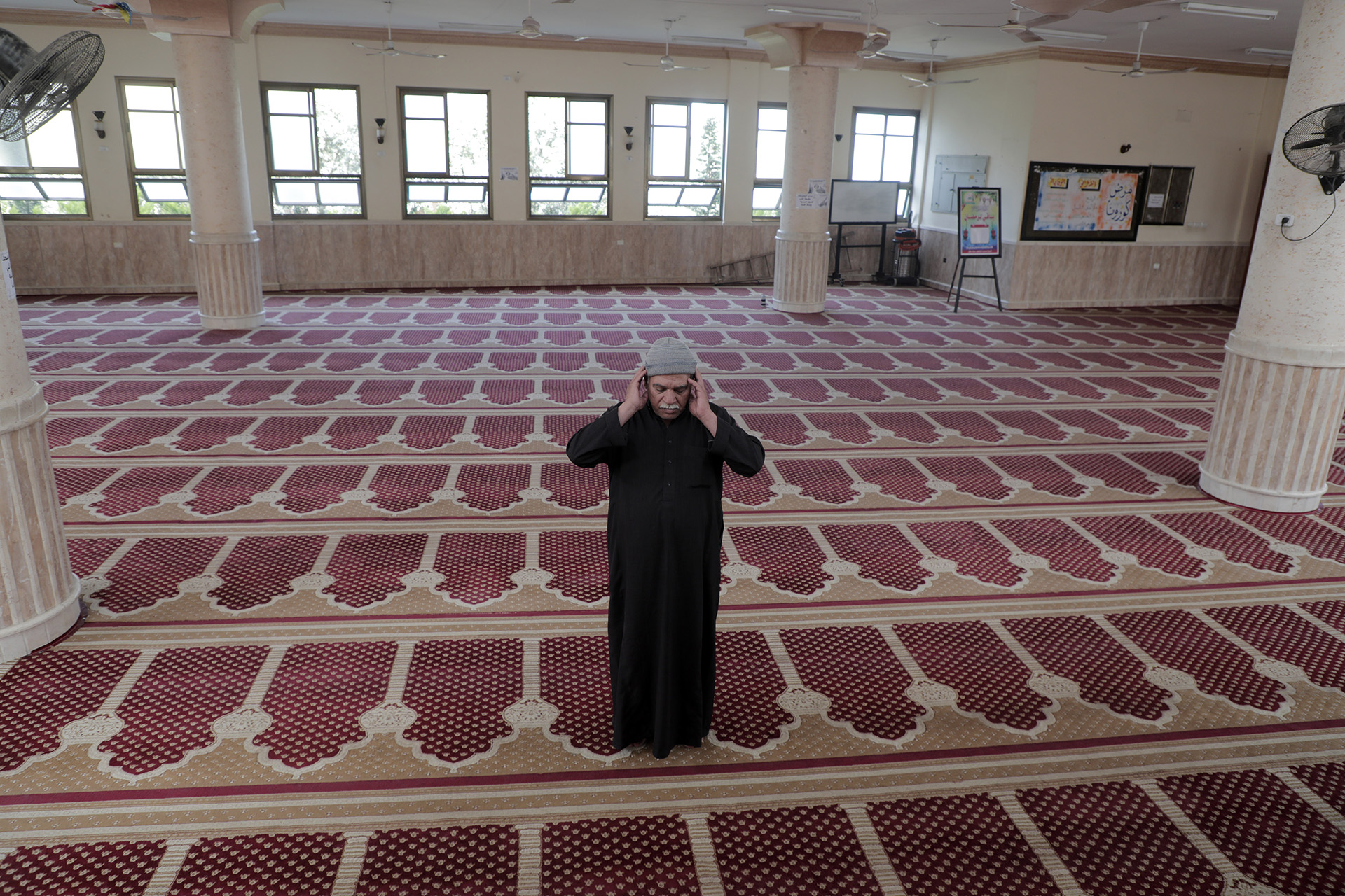 The caretaker of a mosque in Gaza City prays alone