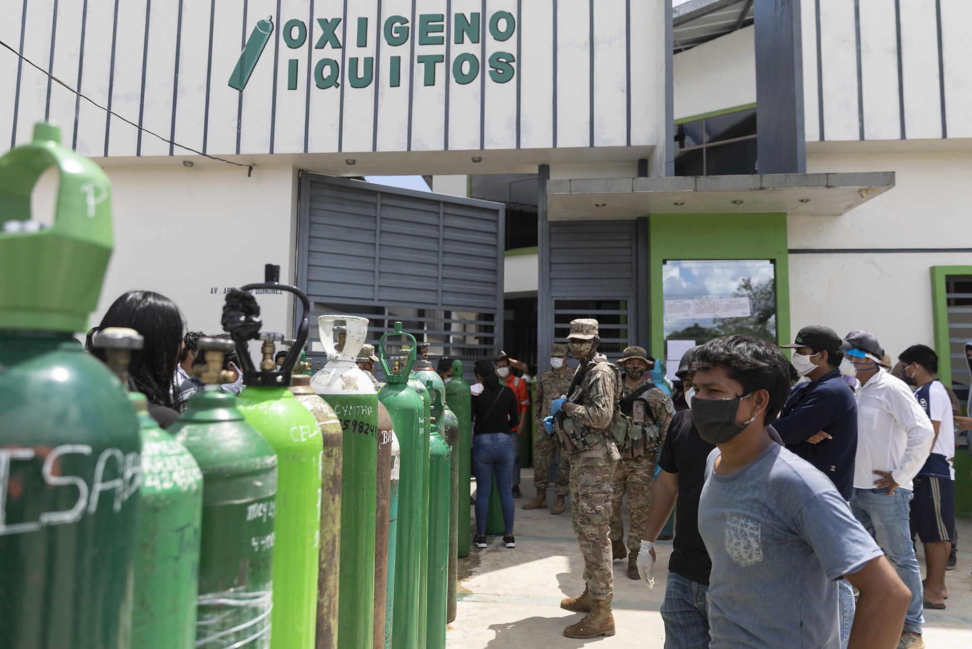 Relatives of hospitalized patients wait in line to fill oxygen cylinders in Iquitos, Peru