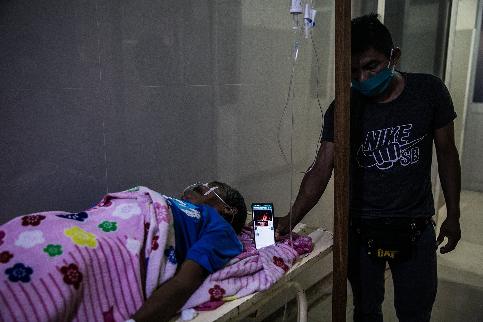 An image of Kakataibo community leader Emilio Estrella's son holding a photo up to his ear