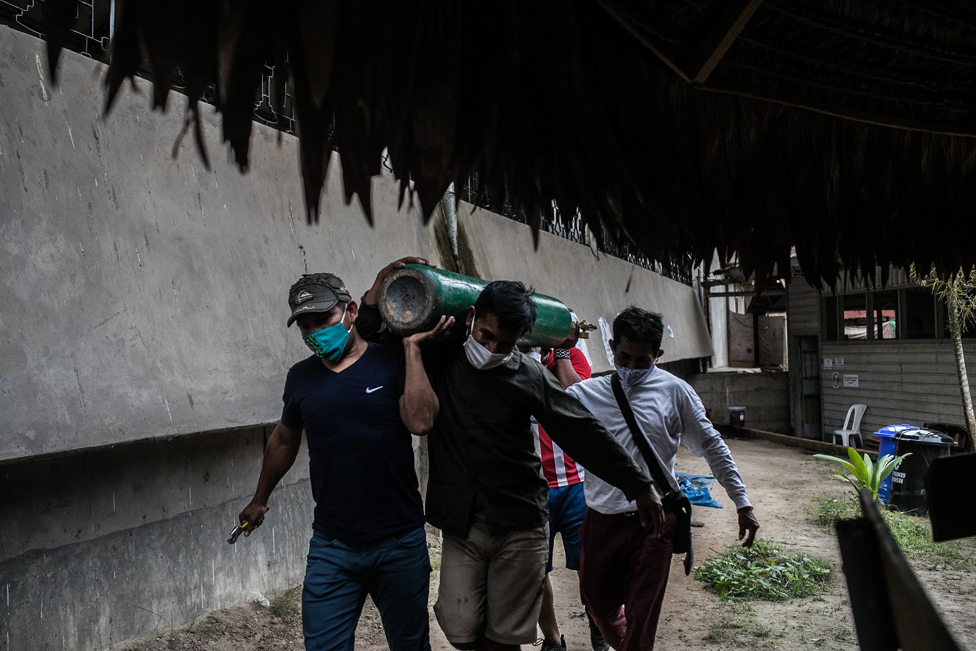 Members of the Comando Matico take an oxygen tank to a plant in Pucallpa