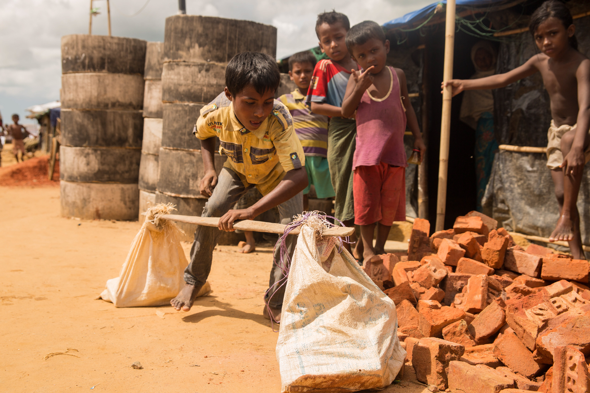 Boy carrying bricks