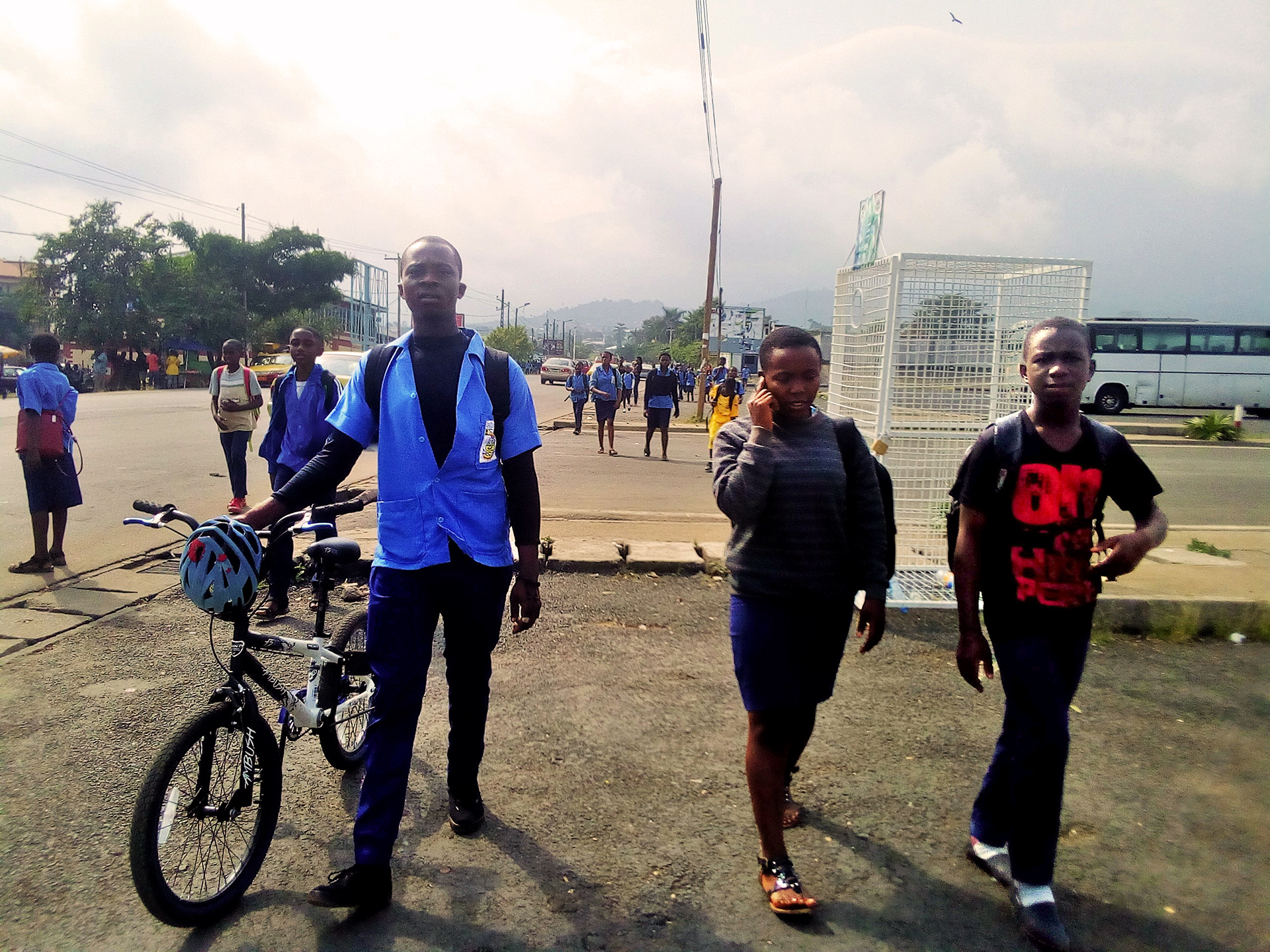 School children returning from school in Buea, one of the few places in the English-speaking regions where some schools still function. School children in uniforms walk on the street toward camera