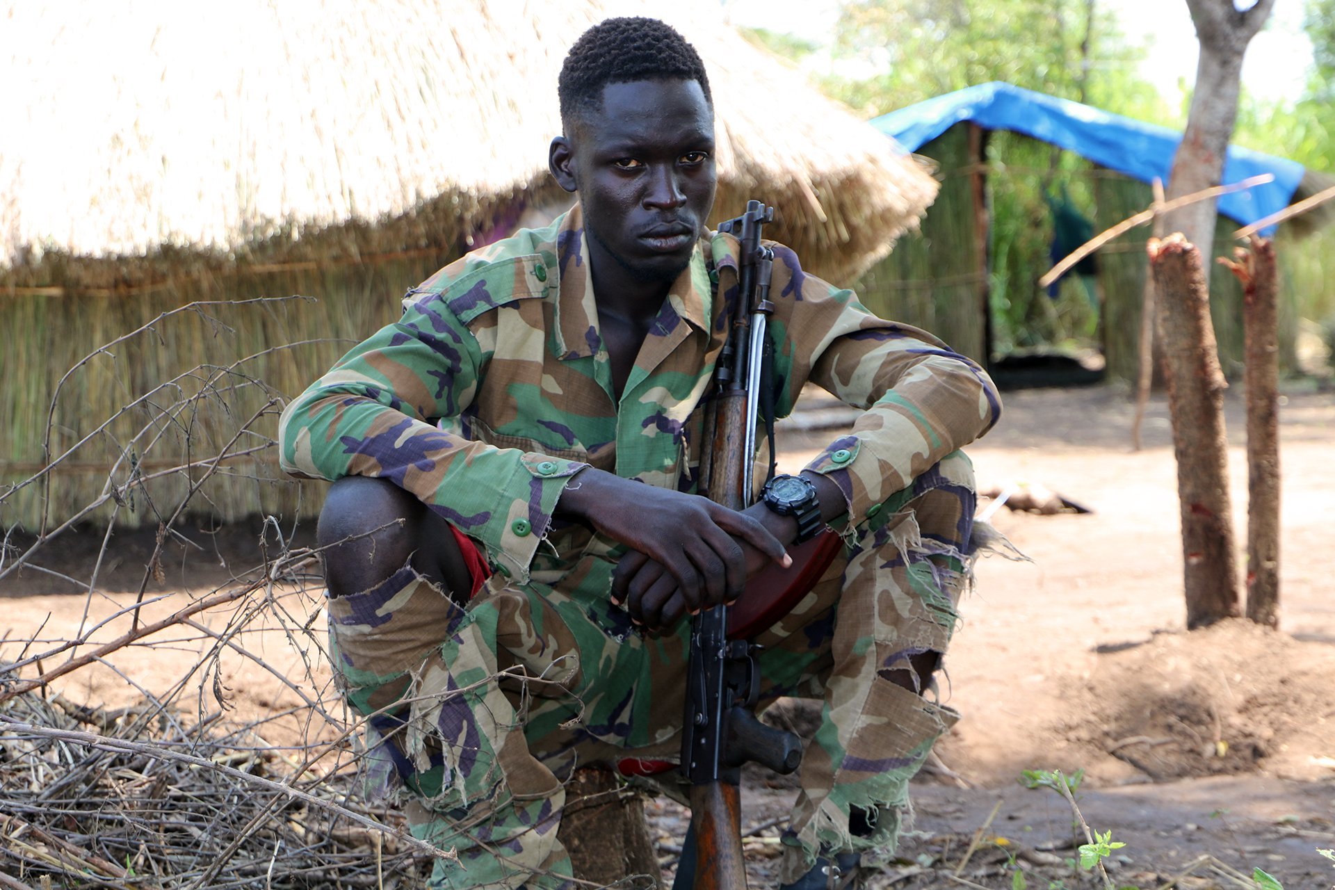 Photo of a opposition fighter sitting with his gun.