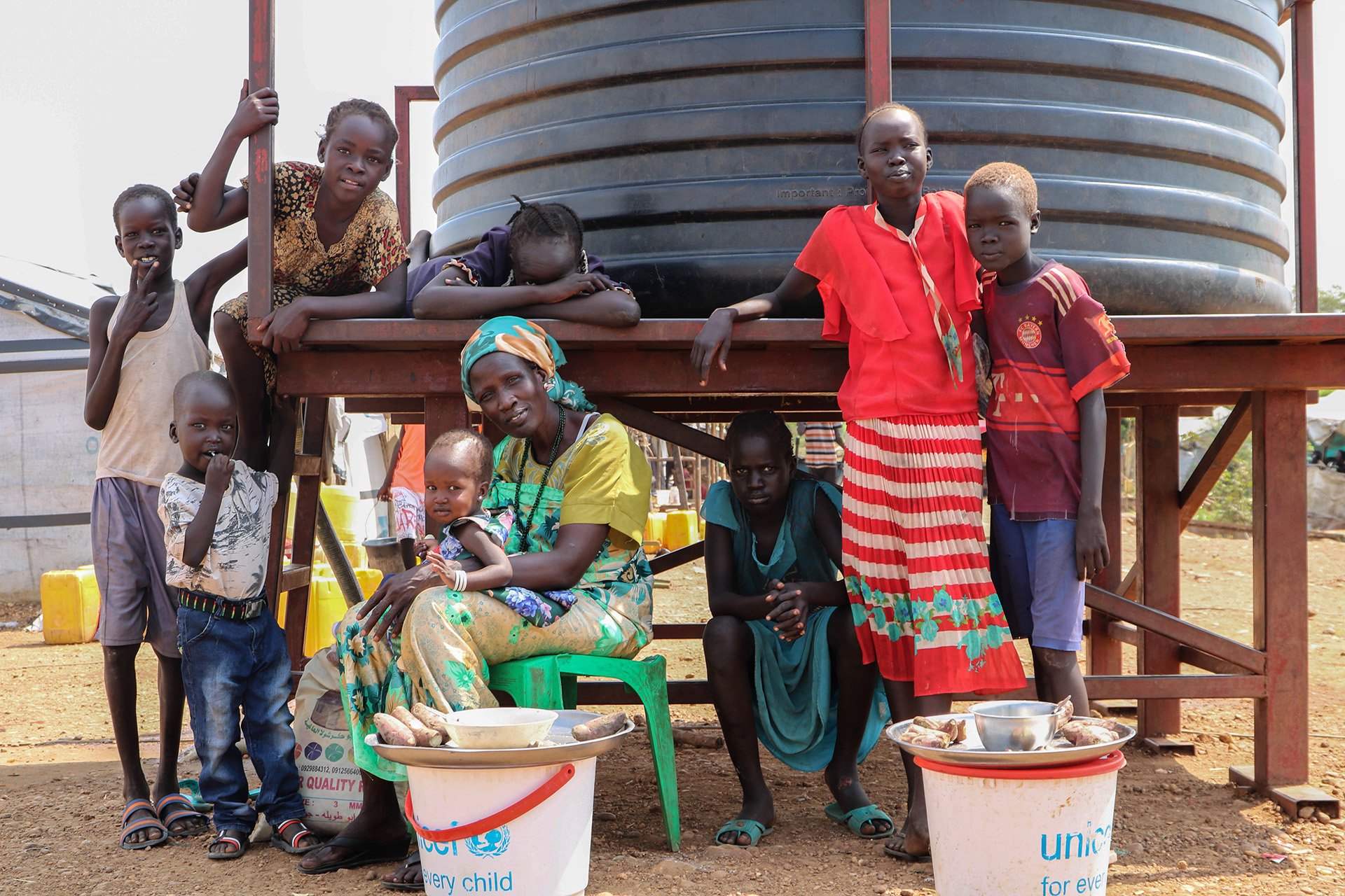 A group of women and children stand together looking at the camera. 