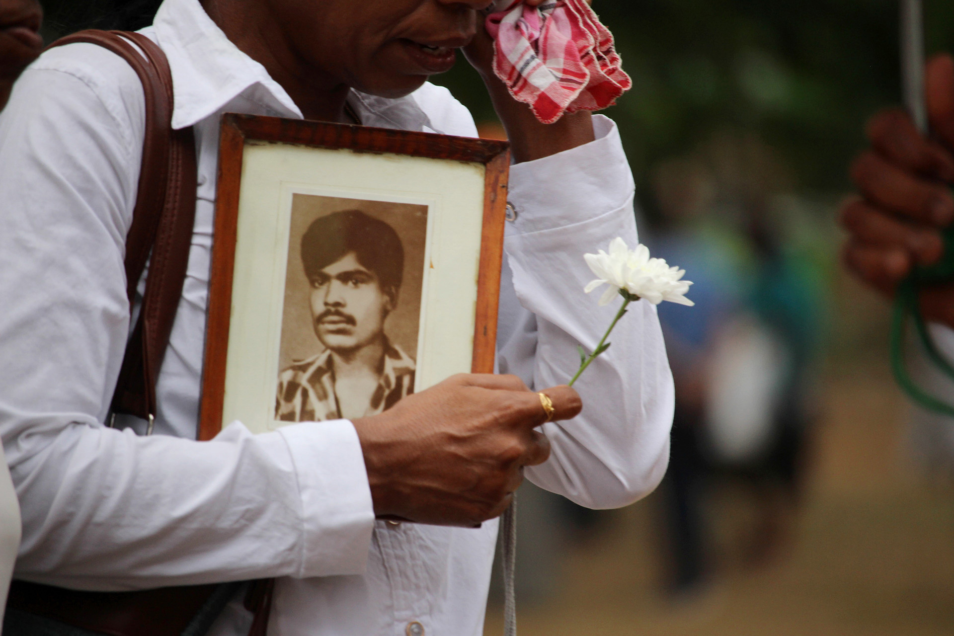 Families hold photographs of missing loved ones during a protest in Sri Lanka