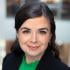 This is a headshot of Rebecca Bell-Martin,. She's an Assistant Professor at el Tecnológico de Monterrey and Visiting Scholar at the Center for US - Mexican Studies, University of California, San Diego. She is smiling at the camera without showing teeth. She's wearing a green blouse and black blazer.