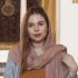 This is a photo of Bianca Carrera. She is a freelance journalist specialised in the Middle East and North Africa based between Spain, Morocco, and Egypt. She is pictured wearing a salmon color scarf, slightly covering her head. She is smiling at the camera without showing teeth. 