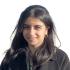 This is a headshot of Rosa Rahimi. She is pictured smiling and wearing a black coat. 