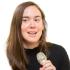 This is an image of Ayla Bonfiglio. She is pictured mid-speech while holding a microphone.