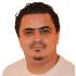This is a headshot of Mohammed Bassiki. He looks at the camera and smiles without showing teeth. He wears a cream coloured t-shirt.