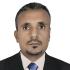 A headshot of Saeed al-Batati. He is pictured looking at the camera, not smiling, wearing a dark suit and blue tie.