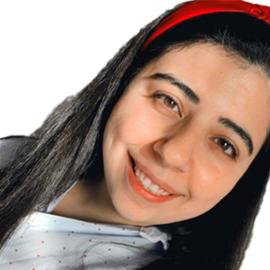 This is a headshot of Zainab Chamoun. She is pictured at an angle smiling at the camera.
