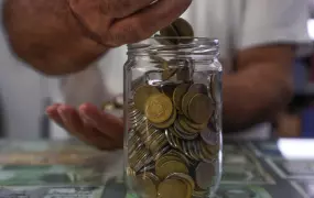 A jar of 250 and 500 Lebanese lira coins at a grocery store in Beirut. The currency has lost so much value the coins are now almost useless.