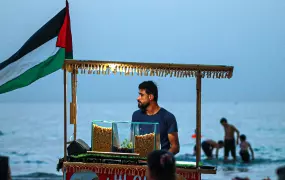Photo of a man selling snacks on a Gaza beach