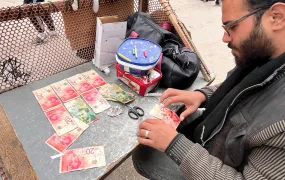 Ahmed al-Jayeh, 29, fixing worn-out bills at a stall he set up in Deir al-Balah's market.