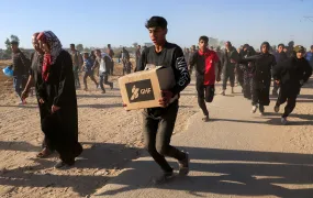A young man carries aid supplies from the Gaza Humanitarian Foundation in the chaos surrounding the first distributions from the US- and Israeli-backed organisation.