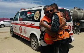 Ahmed Radwan, the leader of a brigade of Palestinian firefighters, hugs one of his team members (Walid al-Khaldy, 41) at the group’s base in the Gaza Strip's al-Mawasi region.