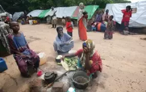 [Somalia] Women prepare food at an internally displaced persons camp in Arare, 12 km from Jamame, southern Somalia, 15 December 2006. Although humanitarian agencies have provided relief aid after the worst floods in 10 years, lack of proper sanitation and