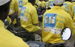 [Benin] Motor bike taxi drivers line up in their new shirts, part of a campaign to get more girls into school. [Date picture taken: 07/24/2006]