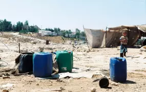 Water containers used by the villagers in Um al Khir. Carmel settlement can be seen in the background