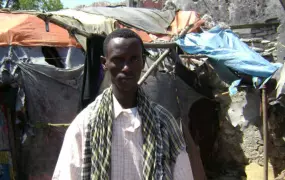 Madeey Suufi, standing in front of what is left of his home where his family was killed when a shell hit. [2 Jan 2008]
