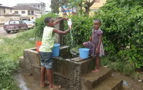 Two children wait at a public fountain in Malabo for water to arrive. UN estimates less than half of the population has access to clean drinking water.