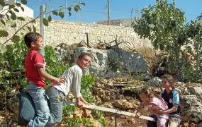 Children of the Saed family playing in Khallet Zakariya. Neighbouring Israeli settlement Alon Shvut can be seen in the background