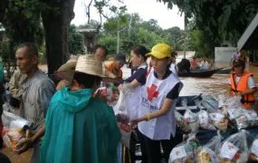 An aid worker for the Thai Red Cross distributes relief assistance. Heavy monsoons rains have affected hundreds of thousands of residents across Thailand