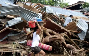 A woman salvages belongings from her ruined village in Mindanao. More than 600 people lost their lives when Tropical Storm Washi struck the island on 16 December 2011