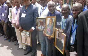 Relatives hold images of departed loved ones at a memorial service for victims of a huge munitions blast on 4 March 2012 in Brazzaville