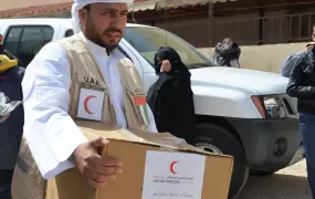 A member of the UAE (United Arab Emirates) Red Crescent distributes aid to Syrian refugees in the northern Jordanian border town of Mafraq. UAE has been active in providing aid in Jordan, but has not done the same inside Syria