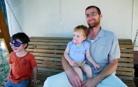 Itai Hemo with his children in front of his caravan in the illegal outpost of Migron, slated for evacuation on August 1