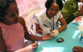 A Madagascan Diabetes Association volunteer checks the blood sugar levels of a passerby at a health fair in Tamatave