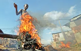 Mohammed Turay burns cables in Freetown’s Kroo Bay slum to extract copper which he sells as scrap