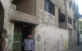 Ayman stand at the front of the house of his parents in Gaza