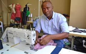 With business skills training and a grant from Jesuit Refugee Service, Clement Mukengeshay, a refugee from the Democratic Republic of Congo, has started a dressmaking business in inner-city Johannesburg