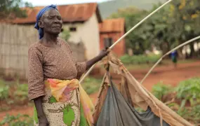 75 year old Mwajuma Hussein, a former farmer from Mine Mpya, sits inside her tent made of plastic sheeting