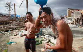 Two boys bath outside in the typhoon-devastated town of Palo, central Philippines. Access to sanitation is a key concern in areas badly affected by Typhoon Haiyan, which struck the area on 8 November 2013