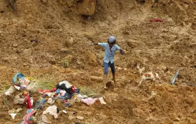 Villager searches among the rubble soon after the massive landslide in the Meeriyabedda village in south-central Sri Lanka late October 2014